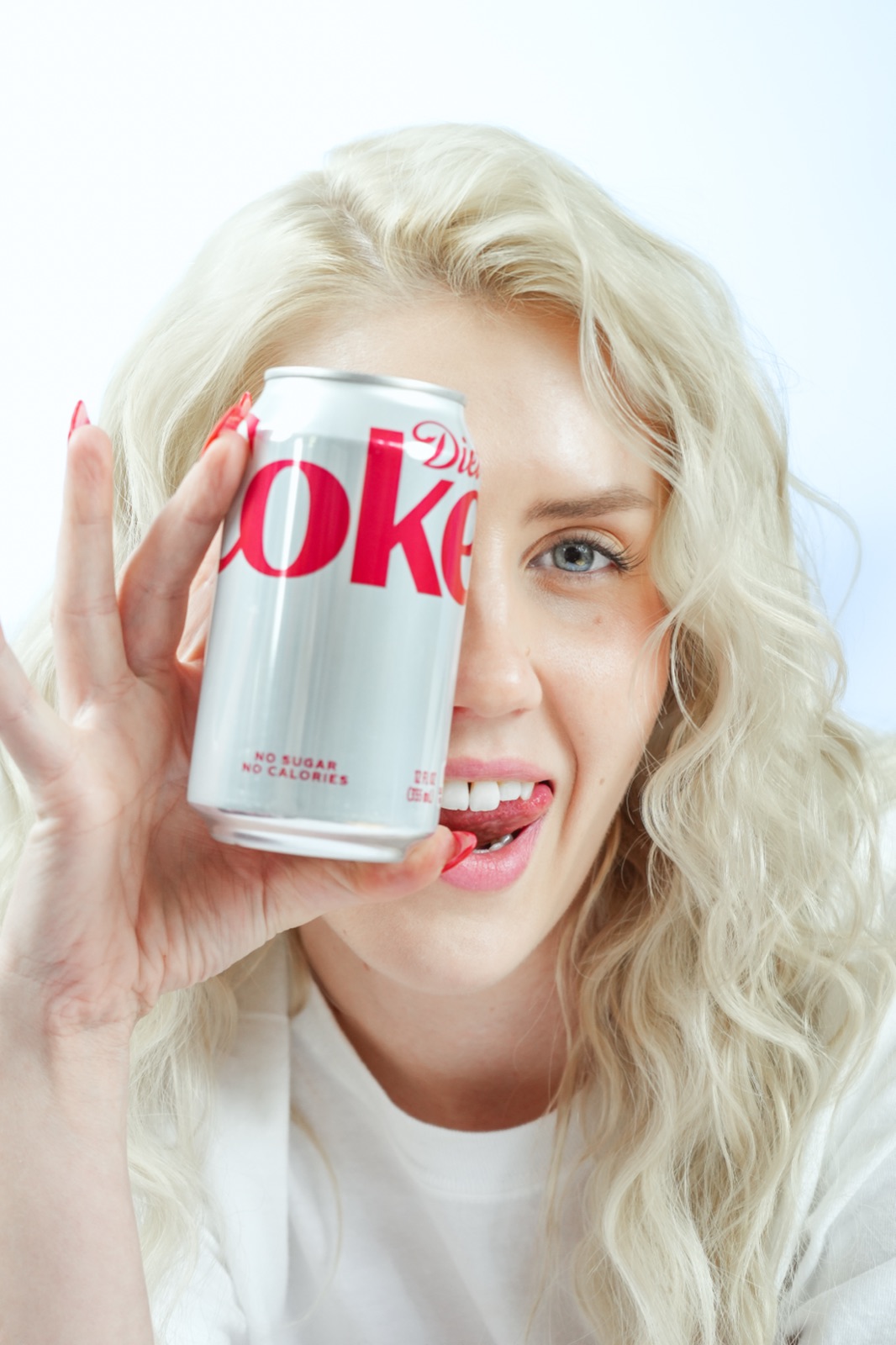 Ida Angelma holding a Diet Coke can over one eye