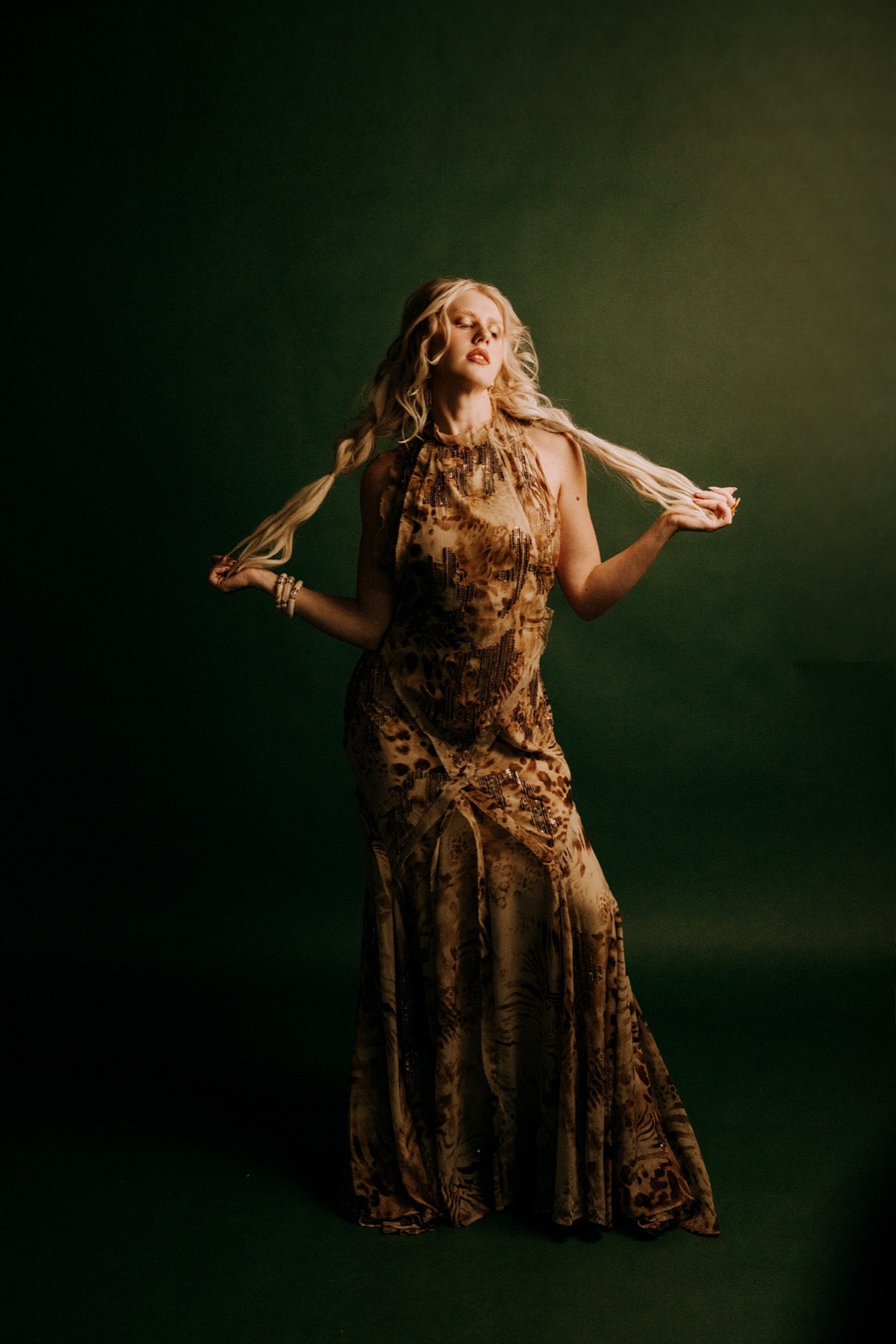 Ida Angelma full length in a sequined gown on a dark green backdrop